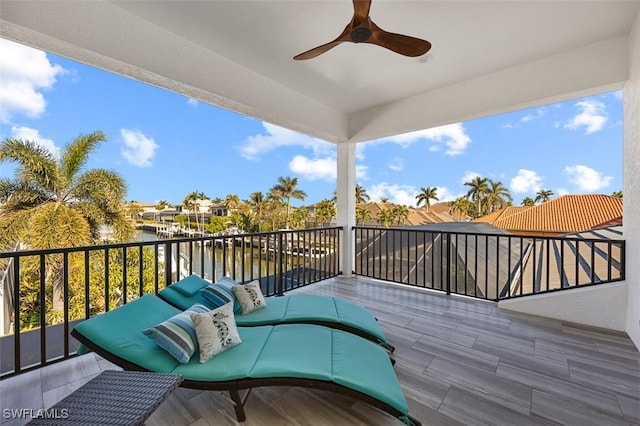 balcony with an outdoor hangout area, a water view, and ceiling fan