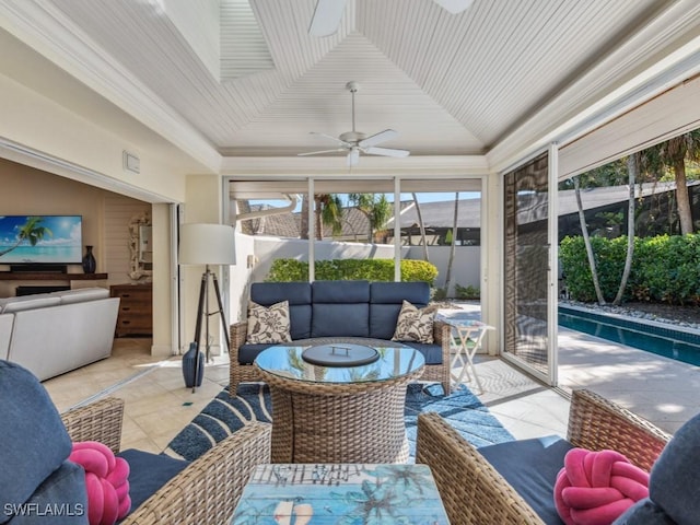 sunroom / solarium featuring ceiling fan, a healthy amount of sunlight, and lofted ceiling