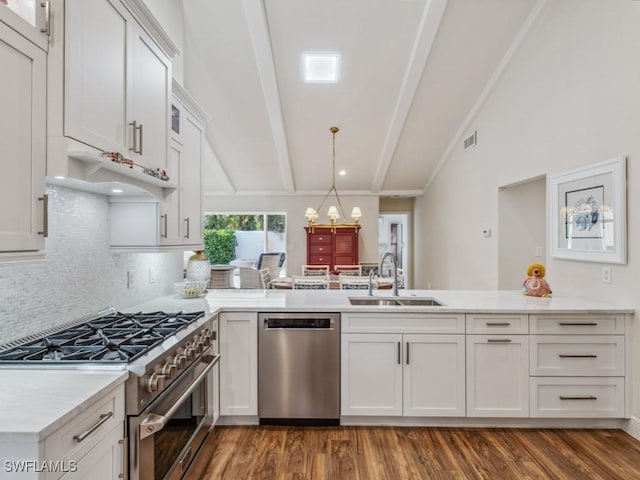 kitchen with appliances with stainless steel finishes, vaulted ceiling with beams, white cabinetry, and sink