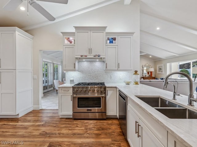 kitchen featuring appliances with stainless steel finishes, vaulted ceiling with beams, plenty of natural light, and sink