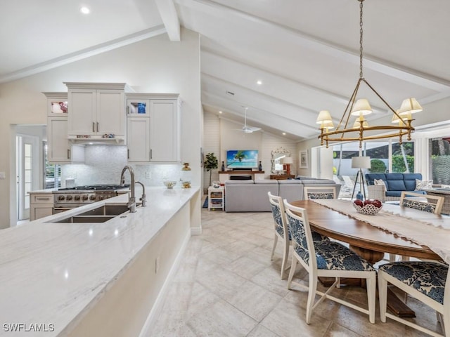 kitchen featuring beam ceiling, light stone countertops, tasteful backsplash, decorative light fixtures, and white cabinets