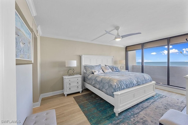 bedroom featuring access to outside, a water view, light hardwood / wood-style flooring, ceiling fan, and ornamental molding