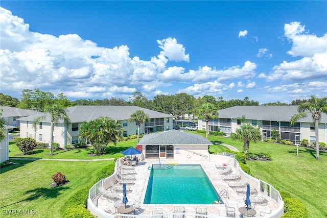 view of pool with a patio area and a lawn