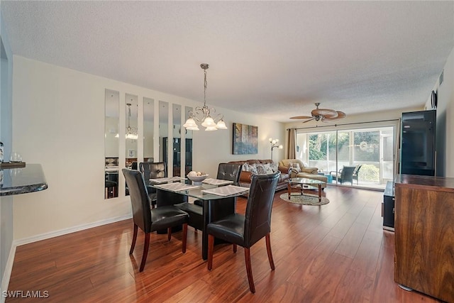 dining area featuring a textured ceiling, ceiling fan with notable chandelier, and dark hardwood / wood-style floors