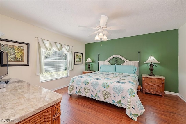 bedroom featuring a textured ceiling, ceiling fan, and dark wood-type flooring