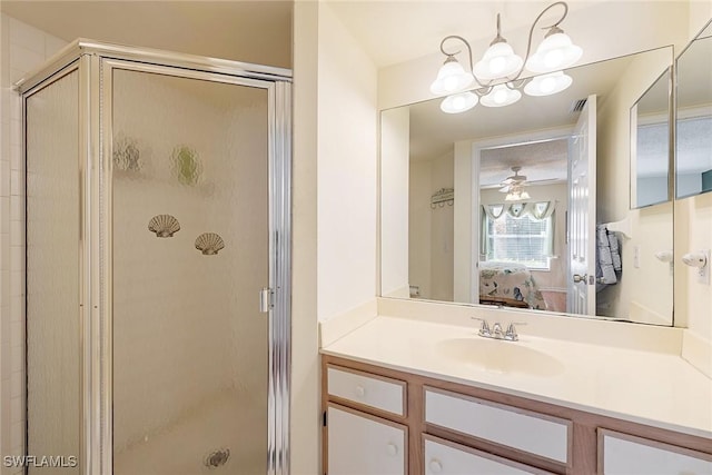 bathroom with vanity, ceiling fan with notable chandelier, and an enclosed shower