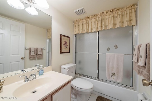 full bathroom with tile patterned flooring, vanity, bath / shower combo with glass door, and toilet