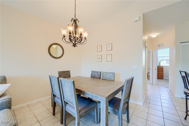 tiled dining space with a chandelier