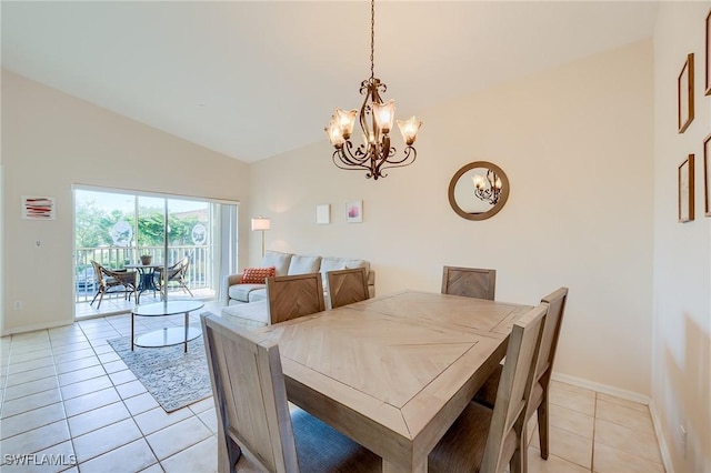 tiled dining area featuring a chandelier and vaulted ceiling