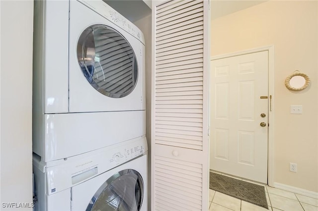 washroom featuring light tile patterned flooring and stacked washer / drying machine