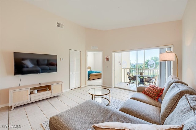 tiled living room featuring a towering ceiling