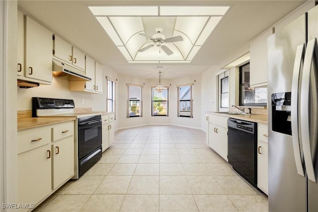 kitchen with light tile patterned floors, ceiling fan, white cabinetry, black appliances, and decorative light fixtures