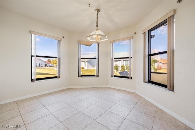 tiled empty room with a chandelier