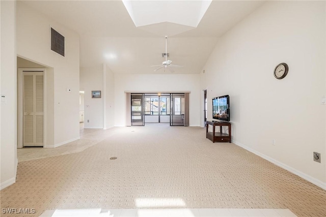 unfurnished living room with high vaulted ceiling, light carpet, and ceiling fan