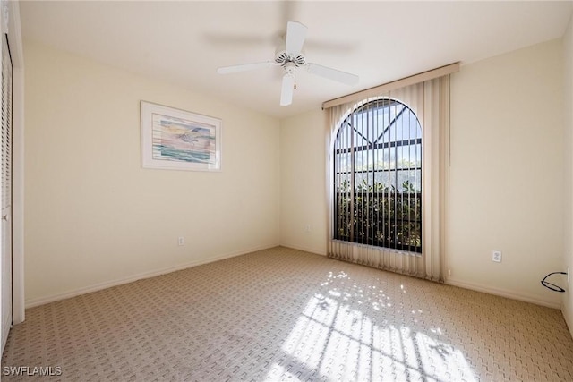 carpeted empty room featuring ceiling fan