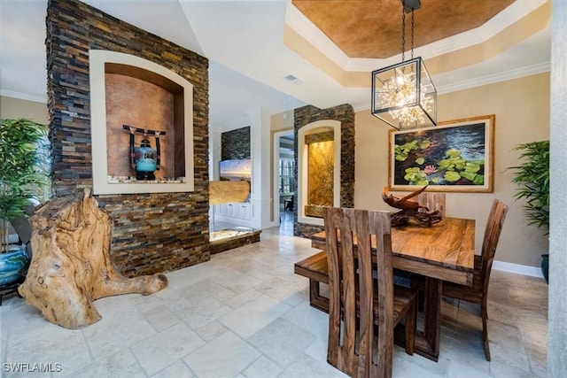 dining space with a raised ceiling and ornamental molding