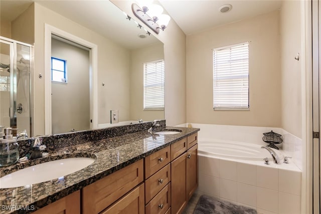 bathroom with separate shower and tub, plenty of natural light, and vanity