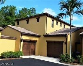 9153 Chula Vista St Unit 13204, Naples, FL 34113 - mediterranean / spanish home with stucco siding, an attached garage, and driveway