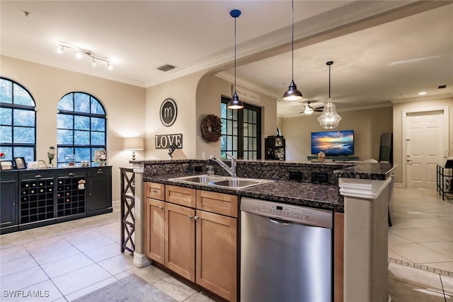 kitchen featuring stainless steel dishwasher, sink, light tile patterned floors, dark stone countertops, and an island with sink