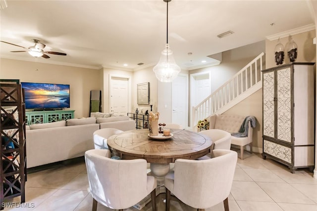 tiled dining space featuring ceiling fan and crown molding