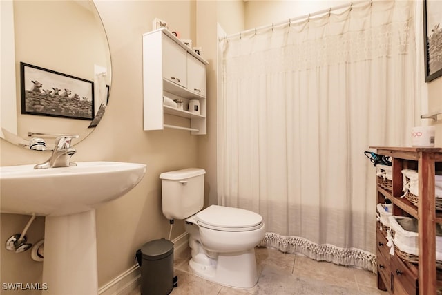 bathroom featuring tile patterned flooring, toilet, and sink