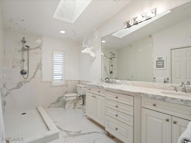 bathroom featuring a tile shower, vanity, a skylight, and toilet