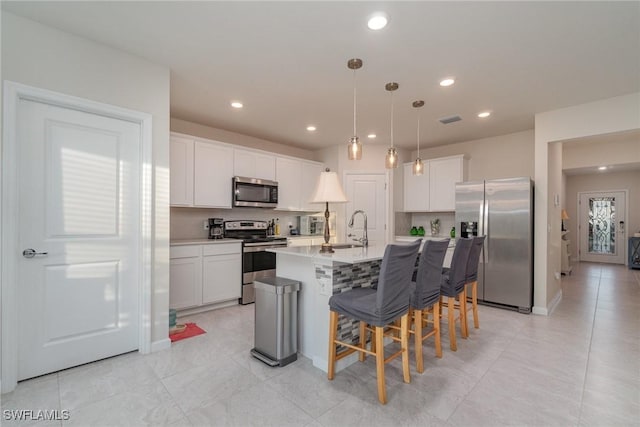 kitchen featuring white cabinetry, an island with sink, and appliances with stainless steel finishes