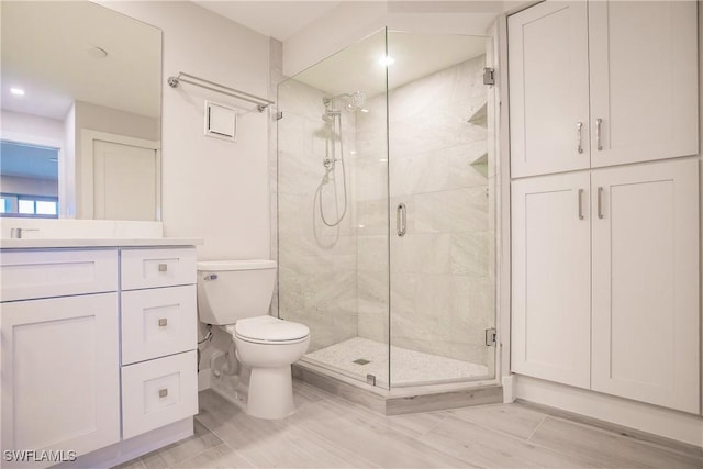 bathroom featuring vanity, toilet, wood-type flooring, and walk in shower