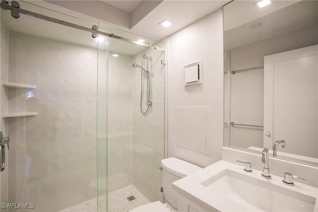 bathroom featuring vanity, toilet, and a shower with door