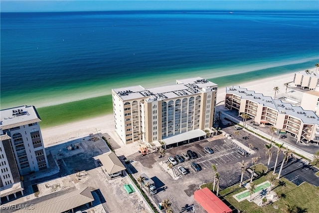 birds eye view of property featuring a water view and a beach view