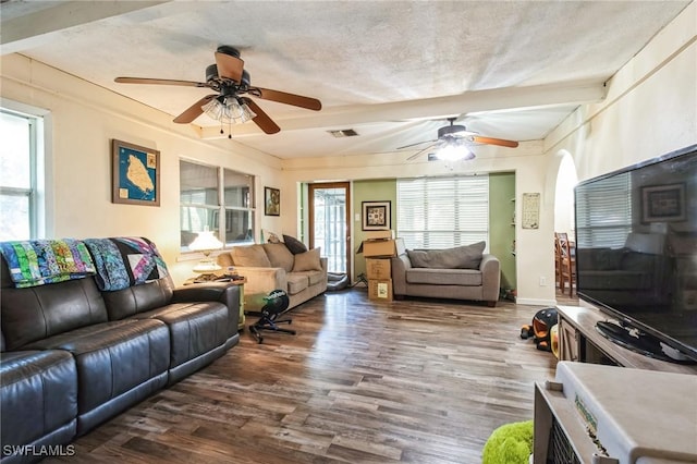 living room with dark hardwood / wood-style floors, beam ceiling, a textured ceiling, and ceiling fan