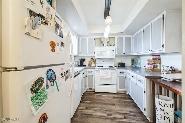 kitchen with dark hardwood / wood-style flooring, white appliances, a tray ceiling, white cabinets, and hanging light fixtures