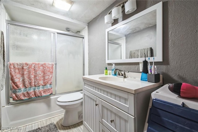 full bathroom featuring vanity, toilet, wood-type flooring, and enclosed tub / shower combo