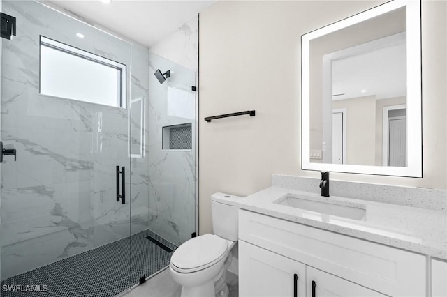 bathroom with vanity, toilet, and a shower with door