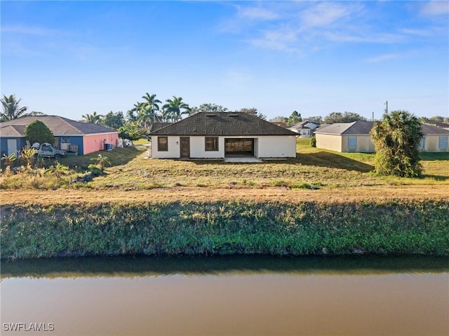 exterior space with a water view and a lawn