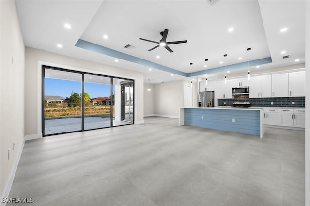 kitchen with pendant lighting, white cabinets, ceiling fan, a kitchen island, and stainless steel appliances