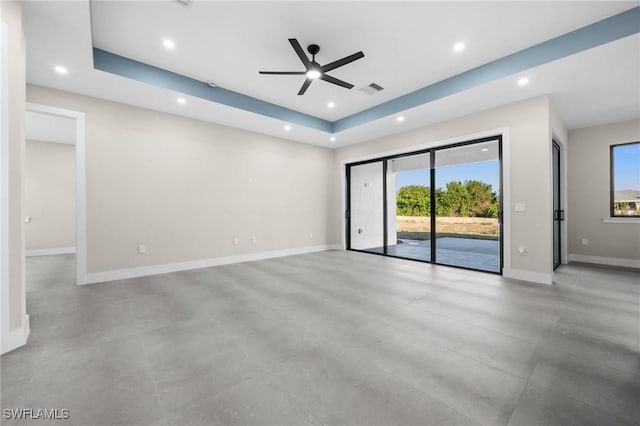 empty room with a tray ceiling and ceiling fan