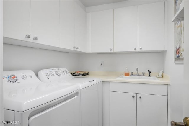 washroom featuring washer and clothes dryer, sink, and cabinets