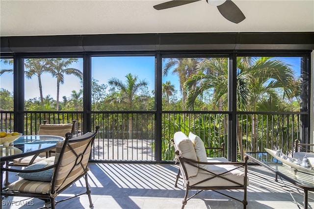 unfurnished sunroom with ceiling fan