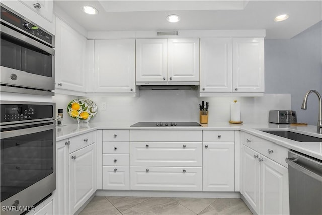 kitchen with sink, white cabinetry, stainless steel appliances, and light tile patterned floors