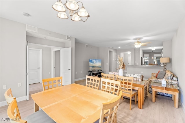 11021 Gulf Reflections Dr Unit 103, Fort Myers, FL 33908 - dining area with visible vents, baseboards, light wood finished floors, and ceiling fan with notable chandelier