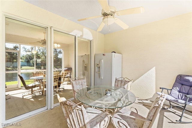 interior space with ceiling fan and a water view