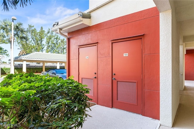 11021 Gulf Reflections Dr Unit 103, Fort Myers, FL 33908 - view of exterior entry with visible vents, fence, and stucco siding