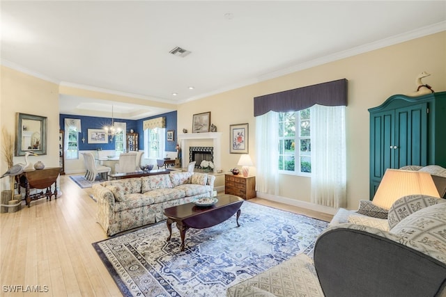 living room featuring light hardwood / wood-style flooring, a chandelier, and ornamental molding