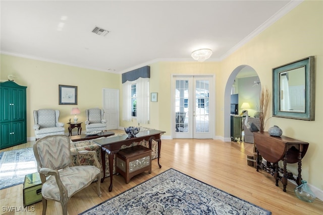 living room featuring ornamental molding, french doors, and light hardwood / wood-style flooring