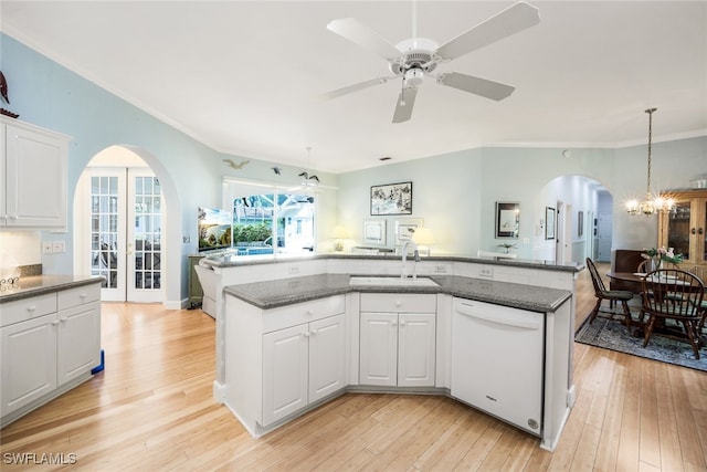 kitchen featuring white dishwasher, white cabinets, sink, light hardwood / wood-style flooring, and an island with sink