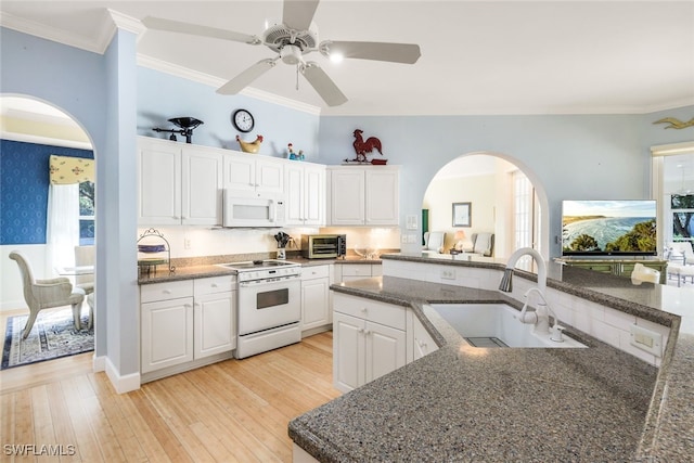 kitchen featuring white cabinetry, sink, kitchen peninsula, white appliances, and light wood-type flooring