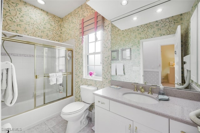 full bathroom featuring shower / bath combination with glass door, vanity, tile patterned floors, and toilet