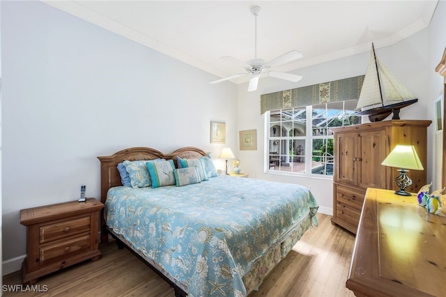 bedroom featuring ceiling fan, crown molding, and wood-type flooring