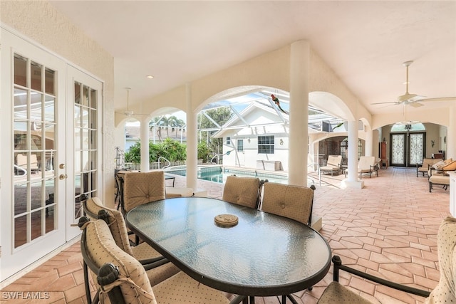 sunroom featuring lofted ceiling, plenty of natural light, ceiling fan, and french doors